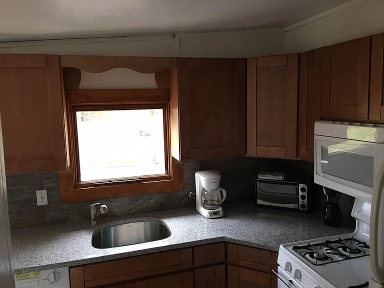 Kitchen has granite counter tops, gas stove, microwave and more