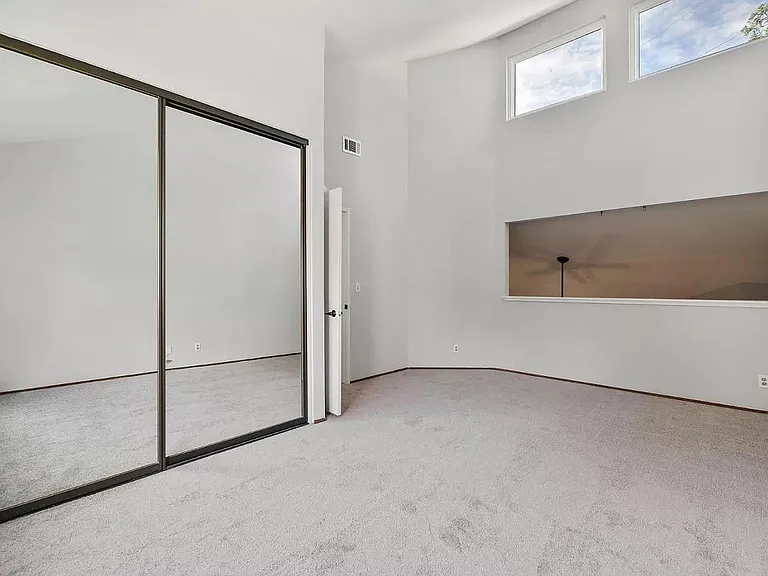 Large 2nd Bedroom with vaulted ceiling and mirror double doors. The rectangular hole is now covered with a floor to 8' high X 12' wide built- in bookcase bolted to the wall for earthquake. Wired for Cable TV.
