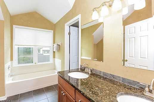3rd Floor bathroom with 2 sinks, tub, shower and vaulted ceiling. Loads of light. Right next to office and direct door to closet and 3rd floor bedroom