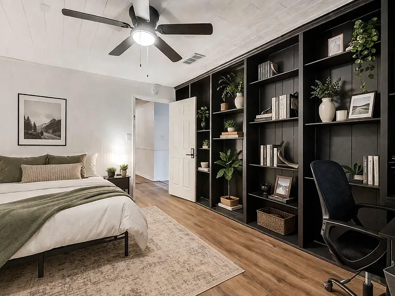 Bedroom with built-in shelving, dedicated desk area, ceiling fan, and wood-look floors for comfortable everyday living.