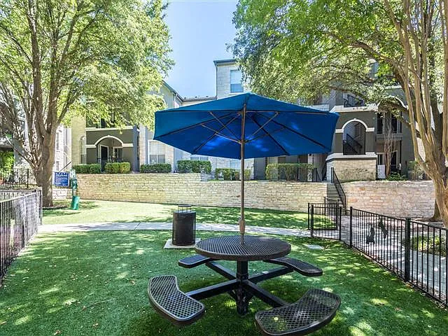 Fenced in dog park with umbrella shaded bench seating