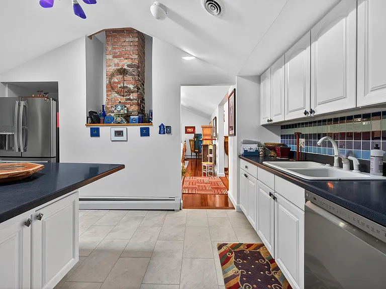 Dining Room connected to the Kitchen. Notice the fireplace chimney exposed in the kitchen.