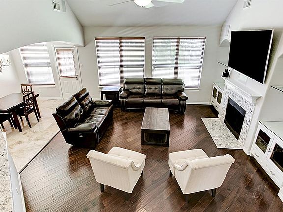 What a fantastic view of the spacious living area in this home.  Warm and relaxing open floor plan with hand grooved hardwood flooring, gas fireplace, ceiling fan and plenty of natural light.