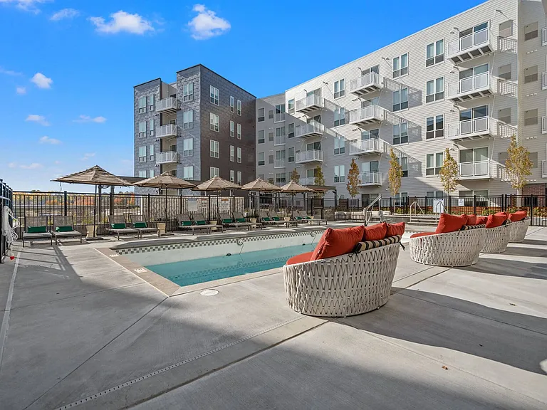 Rooftop amenity deck with heated pool and lounge furniture at The Hallon Luxury Apartments in Hopkins MN