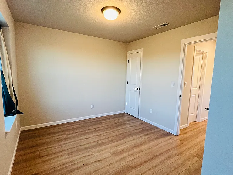 Daylit bedroom with large windows and storage space.