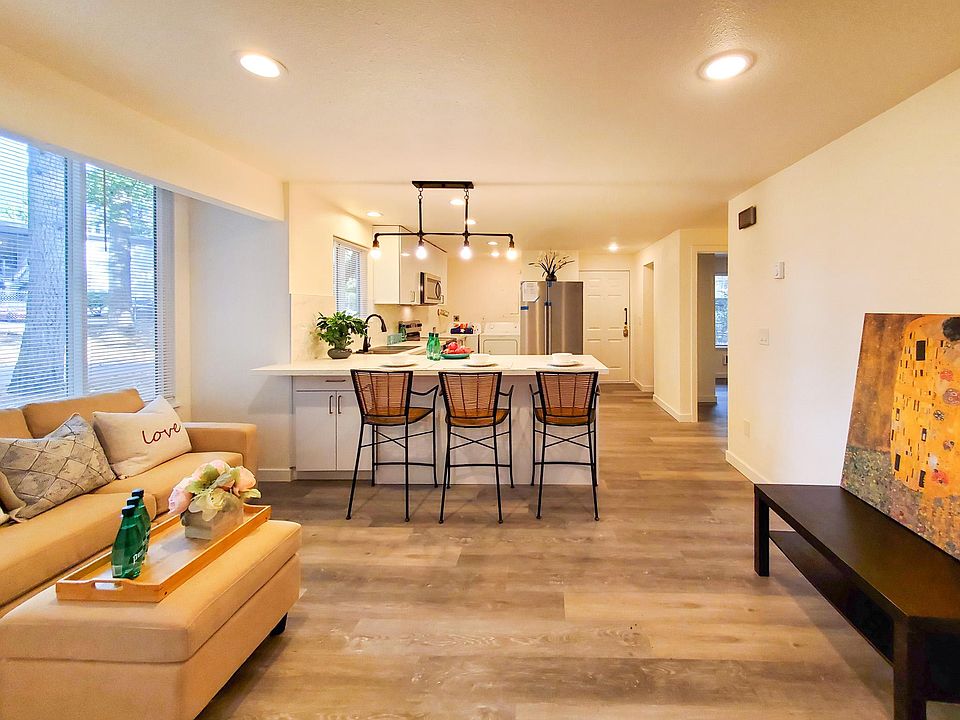 End unit with walls of window shining light into open kitchen and living area