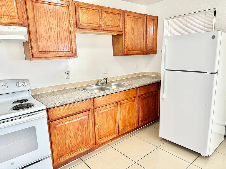 Bright and inviting kitchen with warm wooden cabinetry, modern appliances, and ample counter space.
