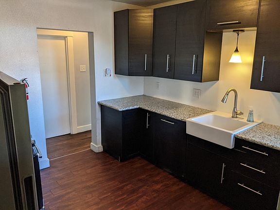 Kitchen with fridge on left side. Gas stove is behind fridge out of view.