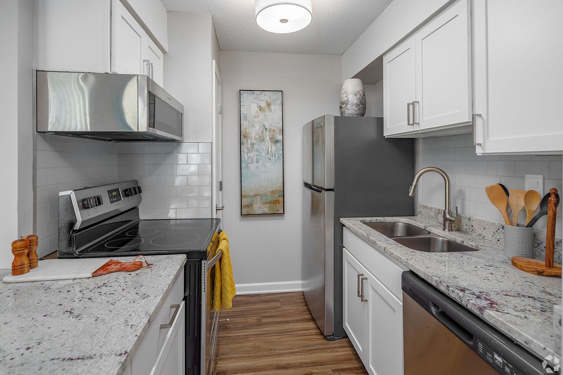Kitchen with granite counters, stainless appliance package, and subway tile backsplash