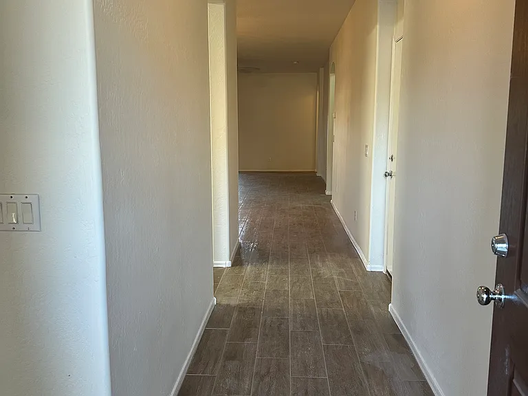 Hallway to 2 more bedrooms, 1 bathroom, and laundry room.