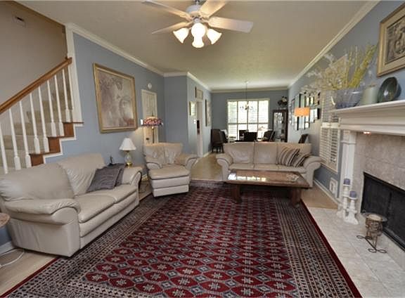 Family room offers gas fireplace, durable laminate wood floors, crown molding and Plantation Shutter