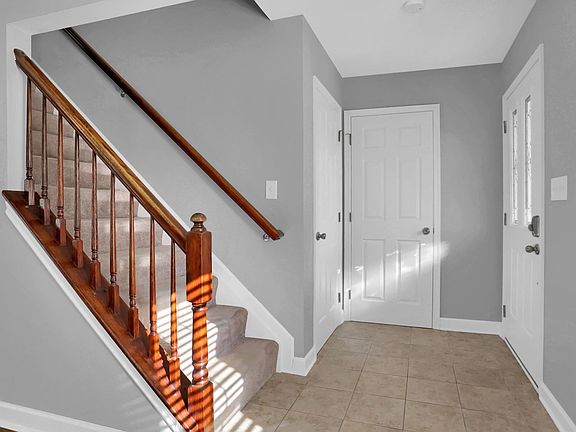 Foyer with easy to maintain tile, coat closet and half bathroom.