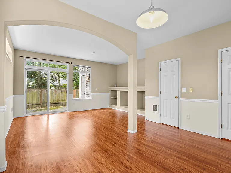 Dining area and living room. Patio exit at the end. Also showing guest bathroom and pantry doors.