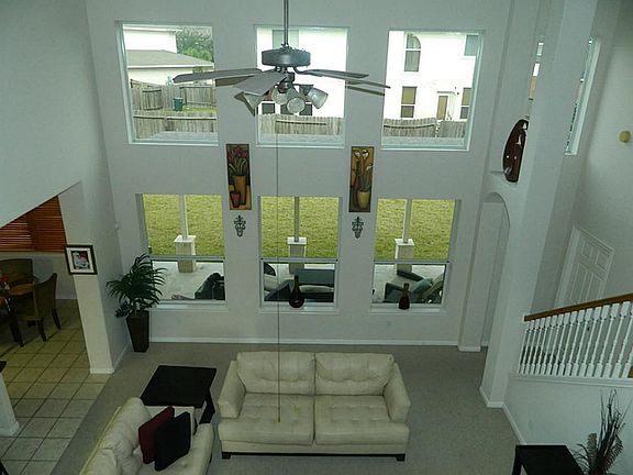 Living room features high ceilings, ceiling fan, fireplace and lots of natural light.