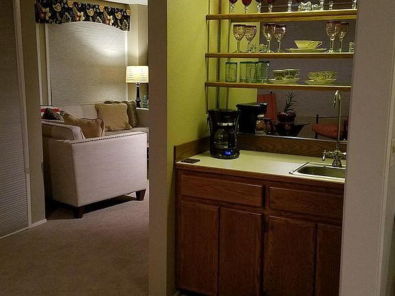 Wet bar dividing living room and den areas