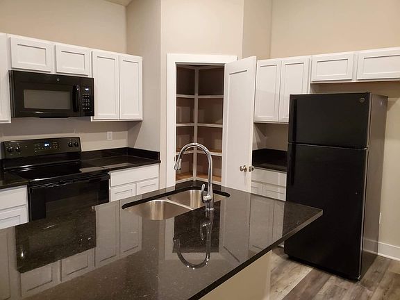 Large open space with a granite center island and corner walk-in pantry