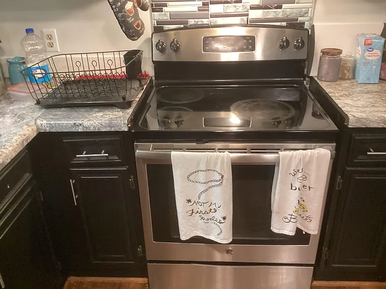 Kitchen area with stainless-steel electric range, ample counter space, and decorative tile backsplash for everyday cooking.