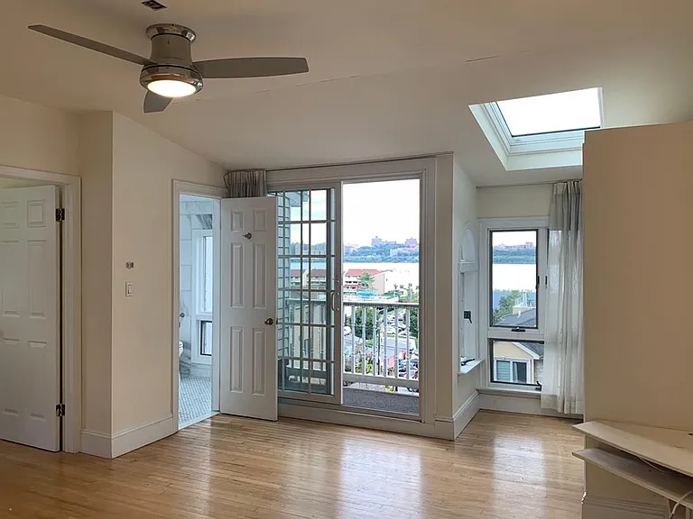 En suite master bedroom features a balcony with dramatic NYC views, skylights, and a large closet.