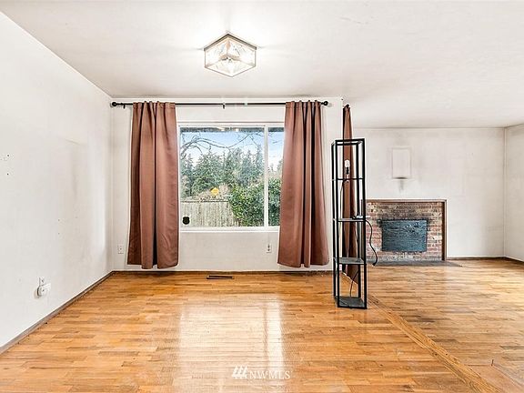 The Formal Dining Room with Bright Window and a Step Down to the Living Room with Fireplace