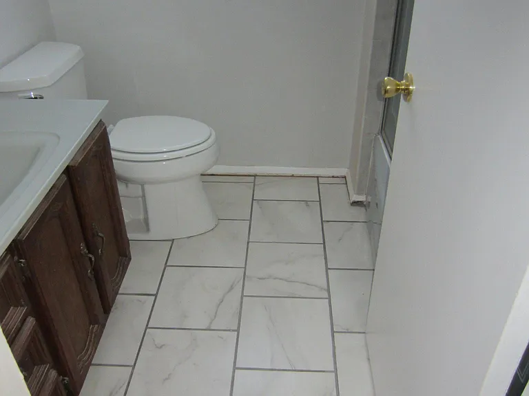 The top level full bath was improved with new marble like tile floor.