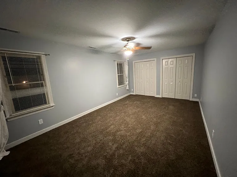 Walking into bedroom 1 from the hallway, looking right. Windows face the backyard