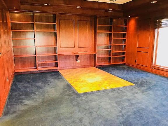 Executive office boast cherry paneling, plush carpeting and 