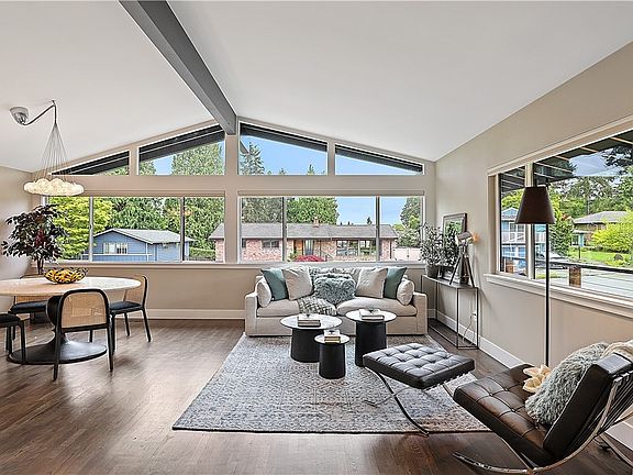 The formal living room with vaulted ceiling and clerestory windows is comfortable and inviting. The room features an abundance of large windows for natural lighting, refinished hardwood, and a gas-burning fireplace (not pictured). A great space to relax and unwind.