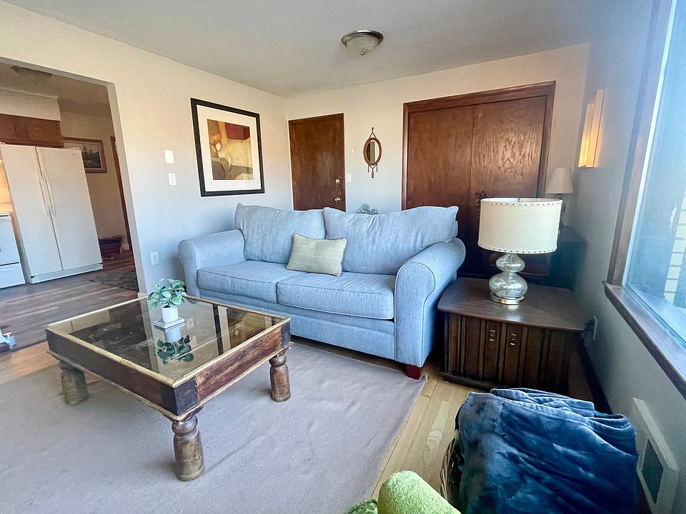 Living room includes a dedicated desk for remote work or studying and an inviting space to relax and unwind.