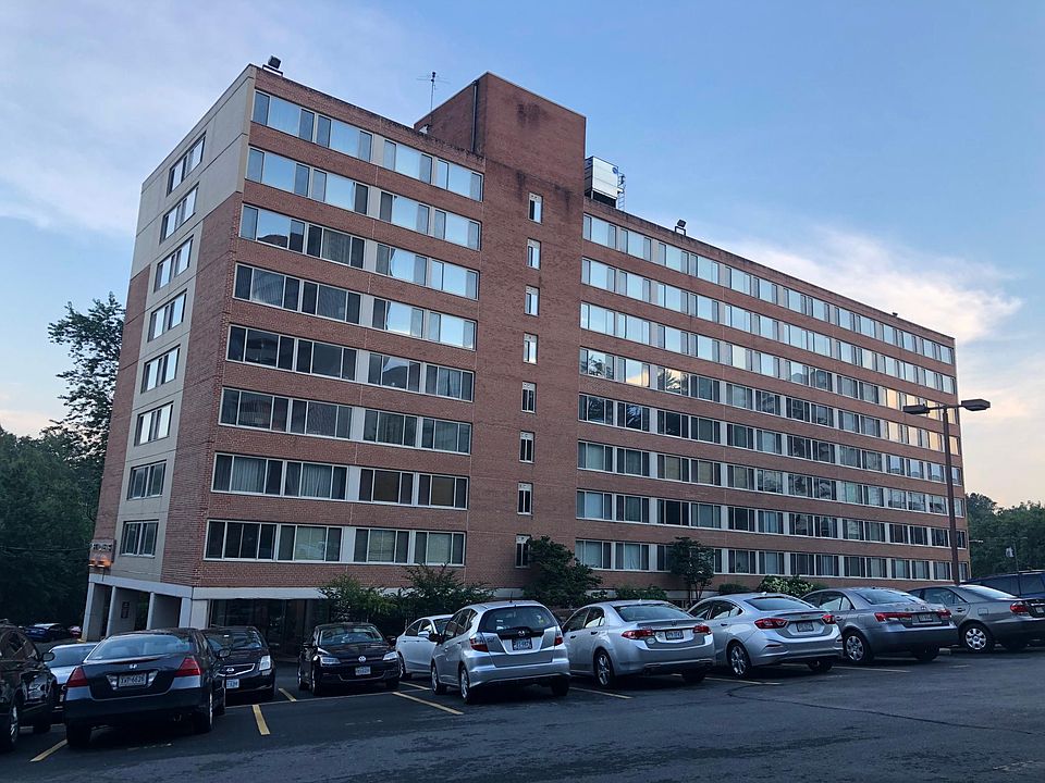 Outside of building showing large private parking lot for residents.