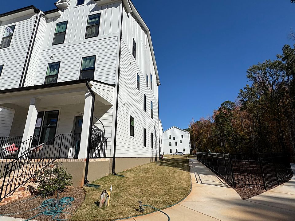 Green wooded area and a dog park next to the home, with a community play area directly behind.