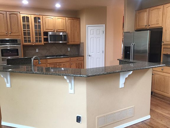 Stainless steel appliances, large pantry, bar seating/serving.