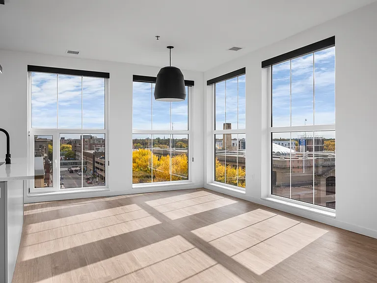 Bright, open apartment space with large modern windows offering a stunning city view and abundant natural light. Bright, open apartment space with large modern windows offering a stunning city view and abundant natural light.
