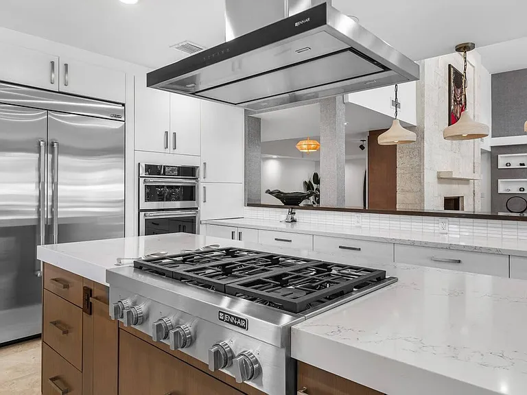 Gourmet kitchen, complete with a professional-grade gas range, stainless steel JennAir appliances, and sleek quartz countertops.