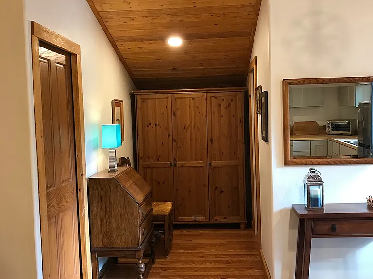 Office secretary desk with chair. Large storage/guest closet with shelving and vacuum, broom and dust pan. Wifi code posted here.