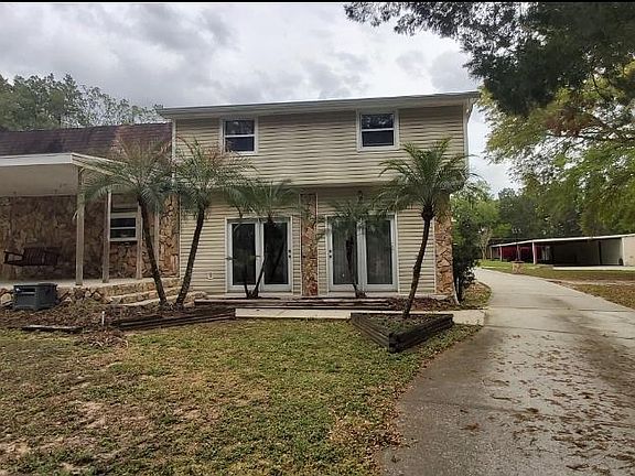 Side view of 1.5 acre property, showing driveway leading to backyard area.