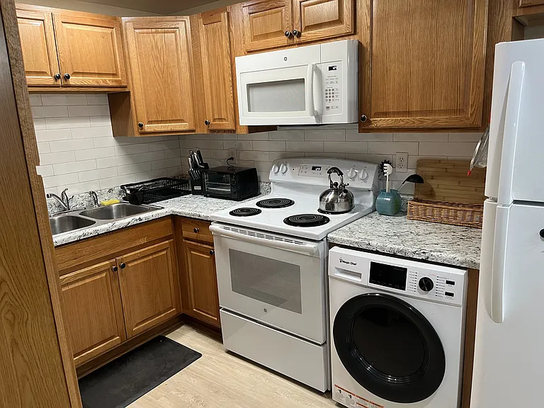 Galley style kitchen with lots of storage and pantry to left. Has a combo washer/dryer unit in kitchen