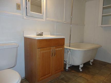 Bathroom with claw foot tub/shower.