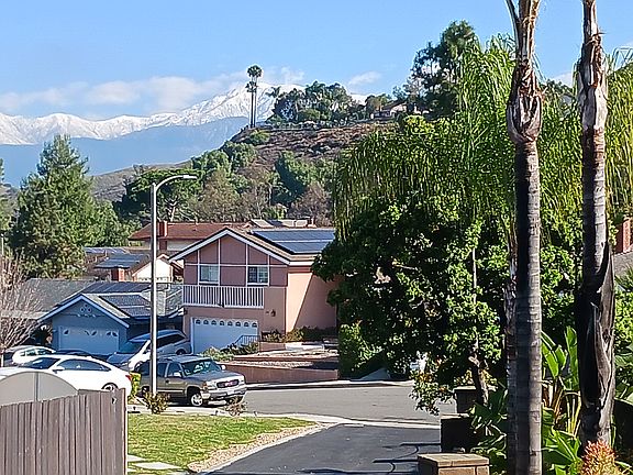 View of snow-capped San Gabriel Mtns. from front of property looking down elevated driveway from front of house.