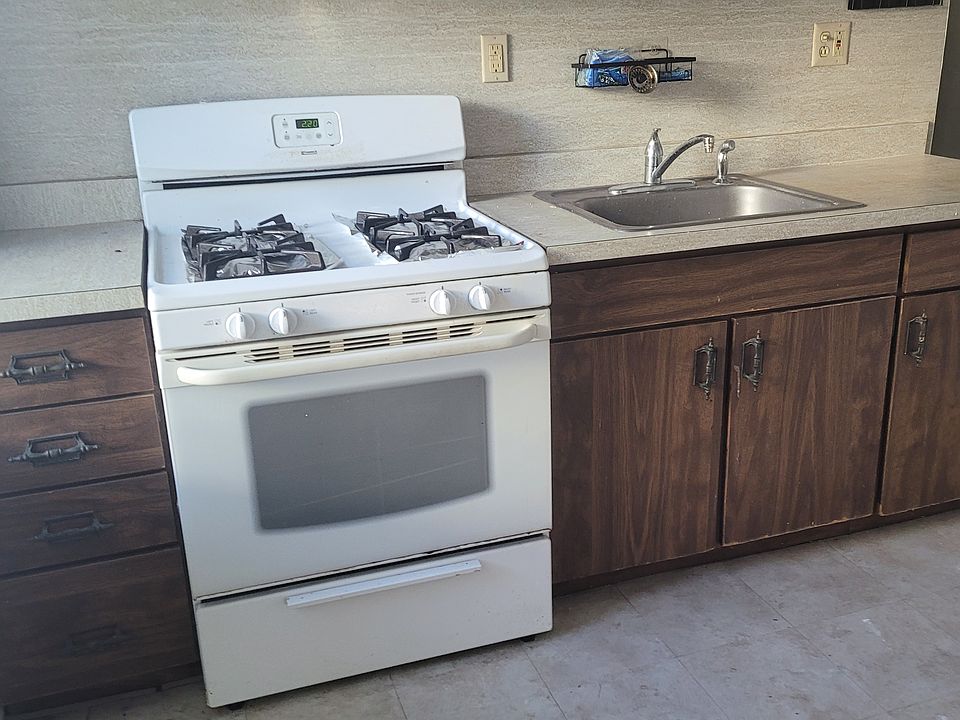 Gas cooking with space in front of the counter for a prep table. Kitchen still allows for a sit--down table.