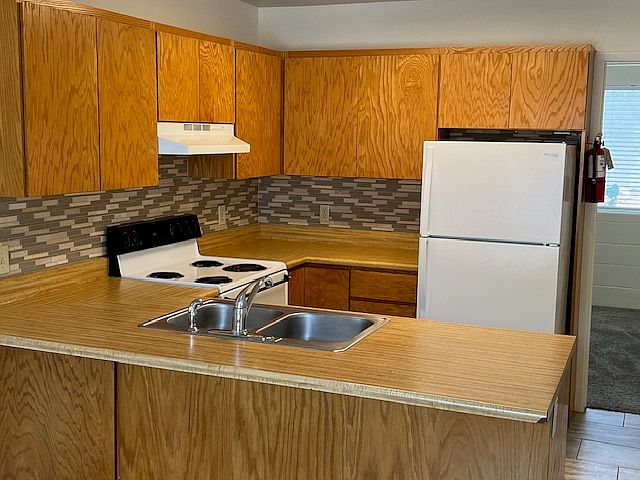 Kitchen includes dishwasher, garbage disposal, stainless steel sink and full size fridge. Title flooring and updated backsplash.