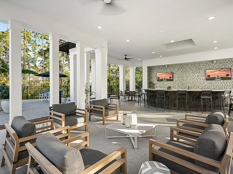 Luxurious outdoor lounge area featuring stylish seating, modern bar, and nature views, perfect for entertaining and relaxation.