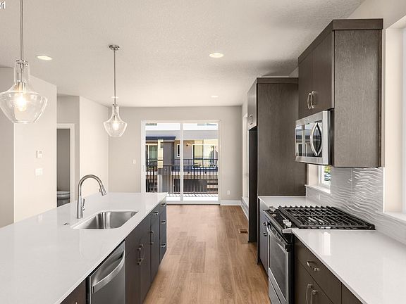 Big island, stainless steel appliances. Slab stone countertops, hardwood floors.