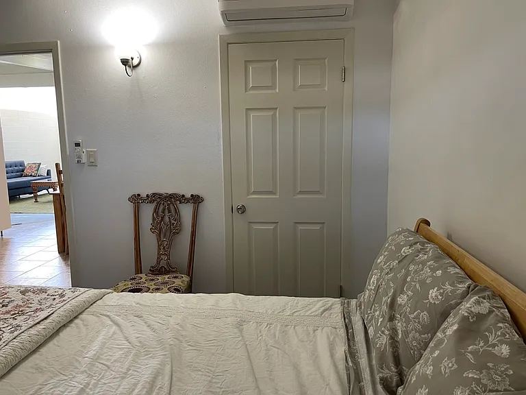 Second bedroom with Queen sized bed. Doors from left to right: dining area, closet.