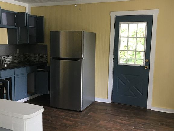 Kitchen stainless steel appliances. Door leads to balcony