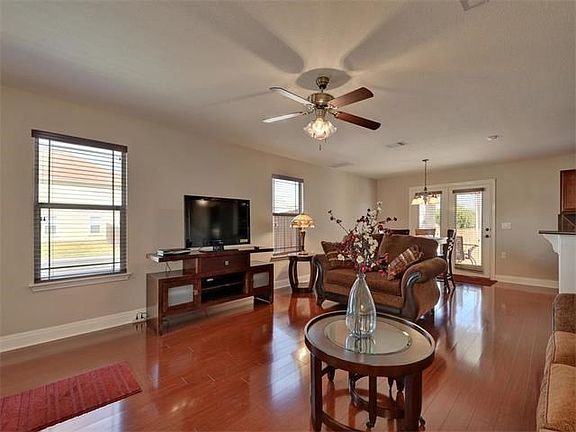 Spacious living room boosts a light and airy feel with gleaming wood floors.