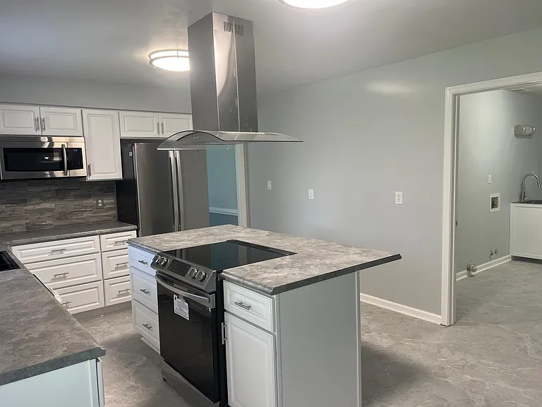 Center island cooking and counter bar with lots of cabinets and drawers.