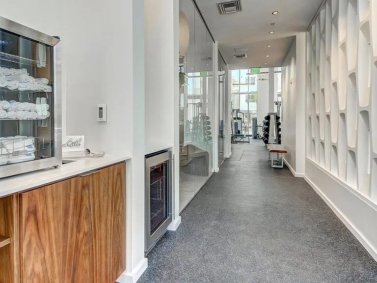 Fitness Studio Entrance Featuring Towel Shelves, Cold Water, and Interior Design Details