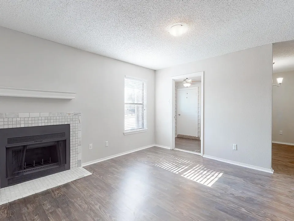 Spacious living area with marble fireplace and wood-inspired flooring