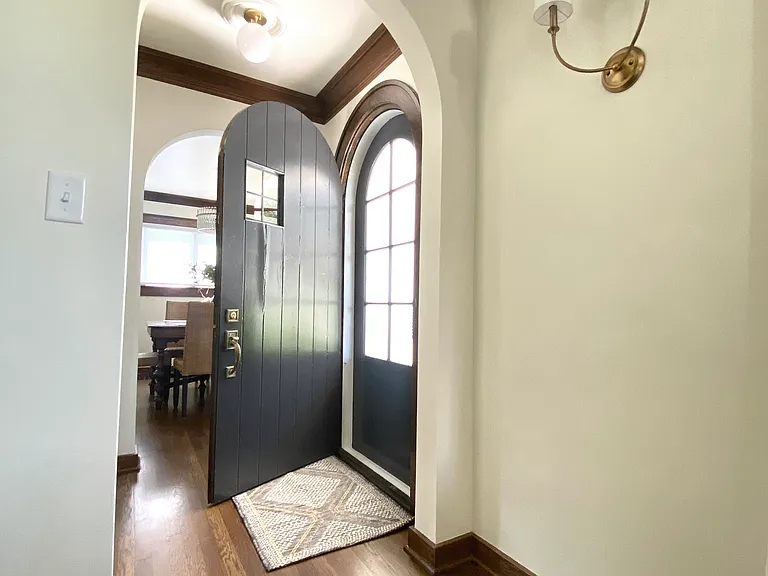 The front door opens to a serene, private front yard filled with beautiful trees, flowers and lush greenery.