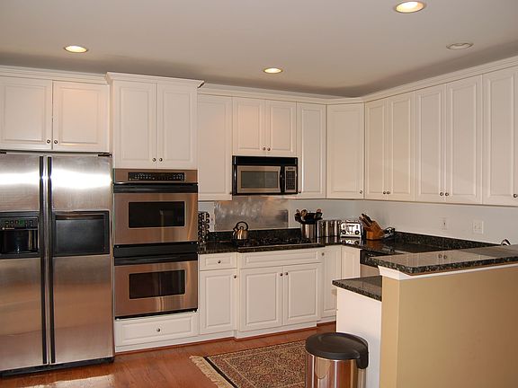 Gourmet kitchen with down-draft cooktop, double wall ovens & granite counters.